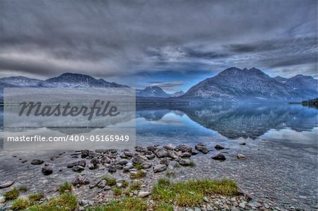 A blue mountain lake with thin white clouds shoot in High Dynamic Range.