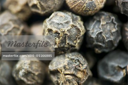 Macro image of whole black peppercorns with limited depth of field.