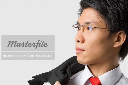 Close up portrait of young Asian businessman looking away