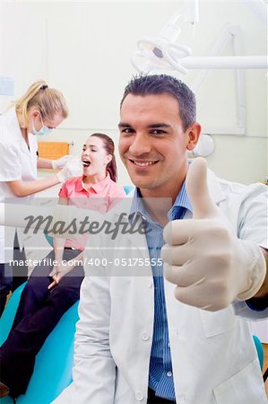 friendly male dentist giving thumb up sign
