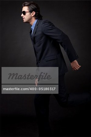 young business man side view in isolated black background