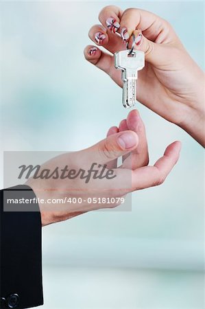 man and woman hand closeup with home keys representing buying and selling new apartment and real estate concept