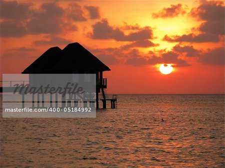 water houses and sunset glow of Maldives island