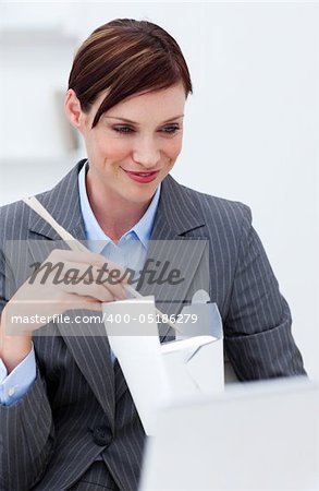 Businesswoman eating chinese food with chopstick at work