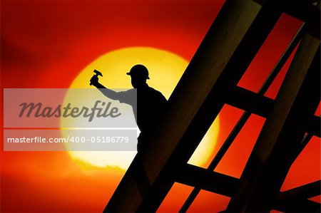 two workers on a roof top with sunset