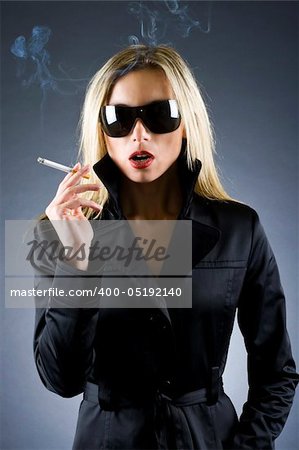 fashion style photo of a gorgeous blond woman holding a cigarette