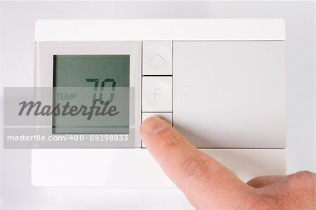 Stock image of hand adjusting thermostat