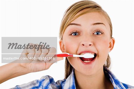 Young girl the brush her tooth on a white background