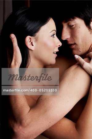 Young adult Caucasian couple in passionate embrace during sexual foreplay