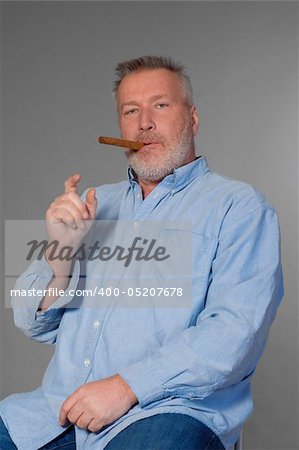 studio portrait of a middle aged man in shirt with a cigar
