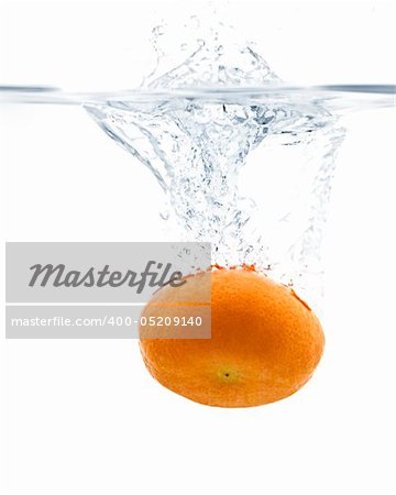 Fresh Tangerine splashing into water with white background