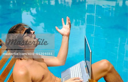 Man takes his laptop to the pool with him