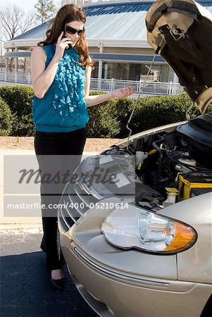 A beautiful young woman having car trouble