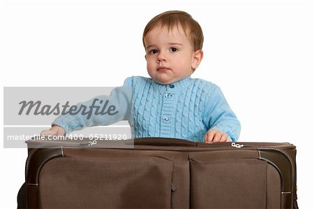 A toddler is packing a suitcase; isolated on the white background