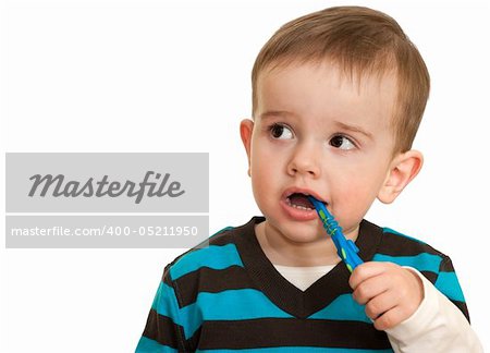 Kid is brushing his teeth; isolated on the white background