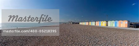 panoramic image of the beach at seaford head near newhaven in east sussex with row of colorful beach huts