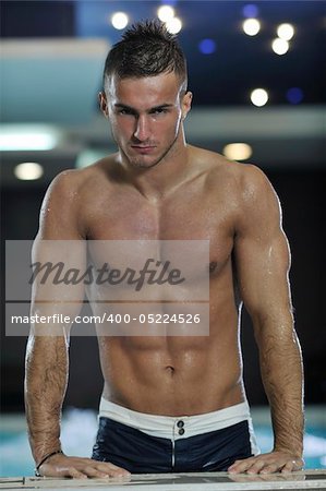 young healthy good looking macho man model athlete at hotel indoor pool