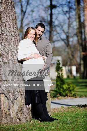 happy young married family couple outdoor in nature have fun and waiting baby and representing young family growth and pregnancy concept