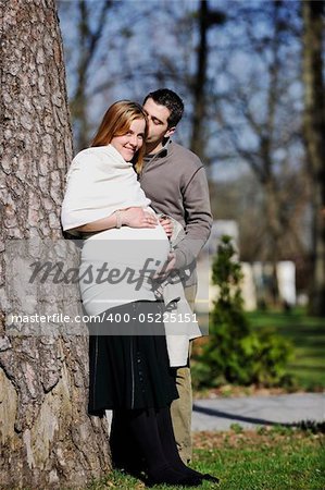 happy young married family couple outdoor in nature have fun and waiting baby and representing young family growth and pregnancy concept