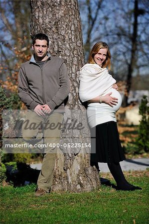 happy young married family couple outdoor in nature have fun and waiting baby and representing young family growth and pregnancy concept