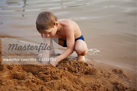 The boy builds on sand