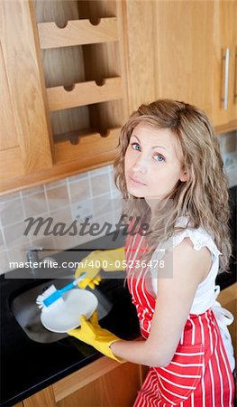 Unhappy woman doing the dishes in the kitchen
