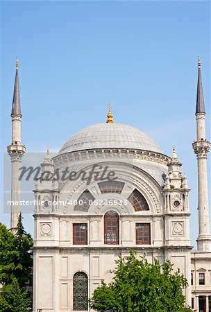 A small ornate mosque against a blue sky background