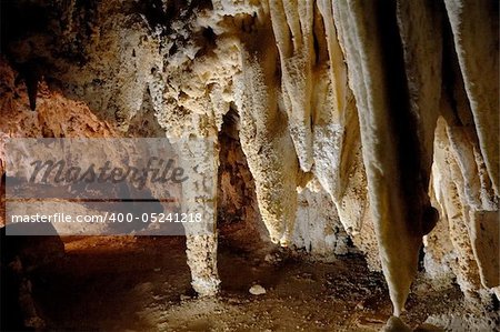 A collection of massive stalactites growing down from the ceiling in Carlsbad Caverns