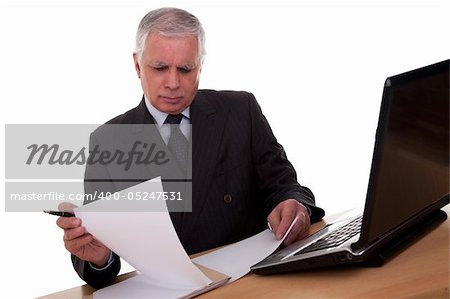 mature businessman  looking to computer, isolated on white background. Studio shot.