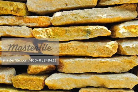 Stacks of large, thick cream and yellowish colored rock slabs