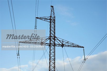 Metal power lines against the blue sky