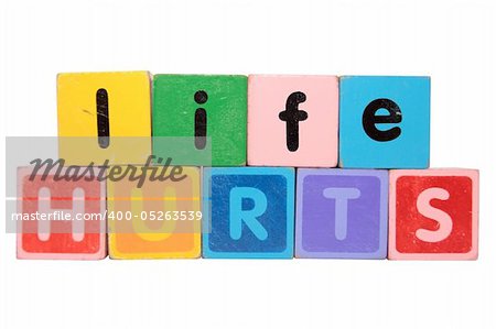 toy letters that spell life hurts against a white background with clipping path