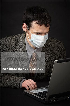 A man in a medical mask diagnoses computer