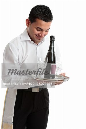 A smiling waiter, bartender, servant or attendant carrying a wine bottle and glasses.  White background.