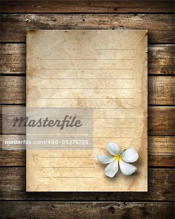 white flower and old blue grunge letter paper on wood