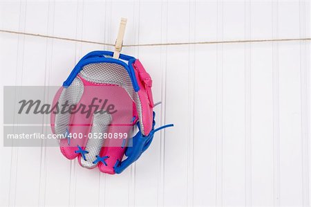 Girl's Baseball Glove Hanging on a Clothesline.