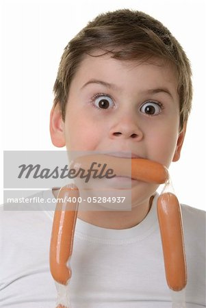 Surprised boy holds sausage in mouth isolated in white