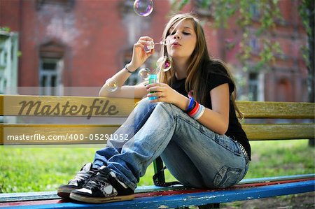 The young girl makes soap bubble