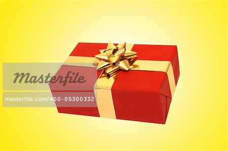 Red christmas present box with gold bow and ribbons over yellow background