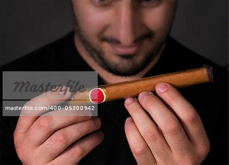 A man admiring a cigar