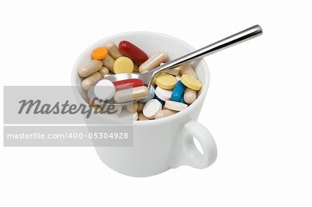 front view from cup of multicolored tablets and capsules with spoon