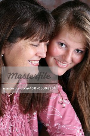Beautiful mother and daughter against a brick-wall background