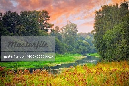 Landscape with small forest river at sunny summer evening