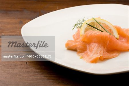 photo of delicious smoked salmon with slice of lemon and fennel