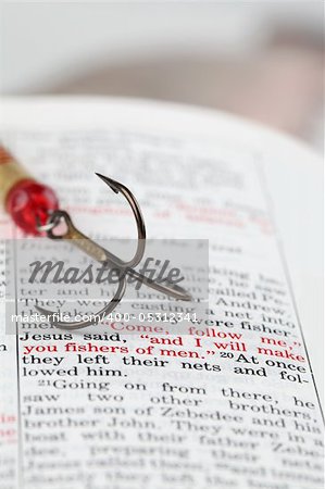 Fishing hook on the Bible with focus on Matthew 4:19 where Jesus calls disciples to be fishers of men