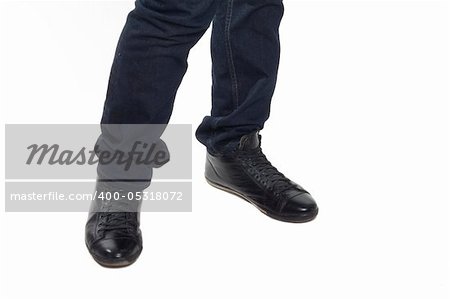 Man's feet in blue trousers and black shoes