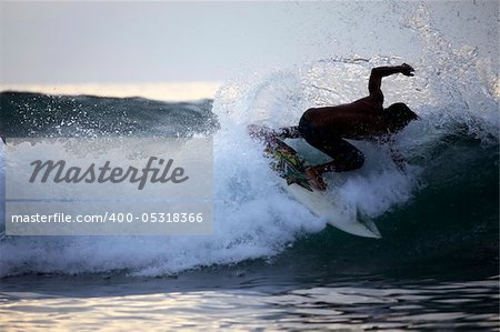 Young men - the surfer in ocean. Bali. Indonesia