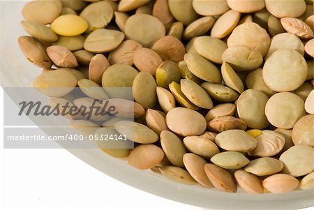A cup of lentils on white background - closeup