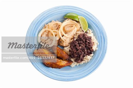 Traditional Cuban roast pork dinner with black beans, rice, and plantains. Isolated on white with clipping path.