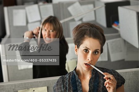 Female office worker thinks while her colleague threatens to stab her with a Samurai sword
